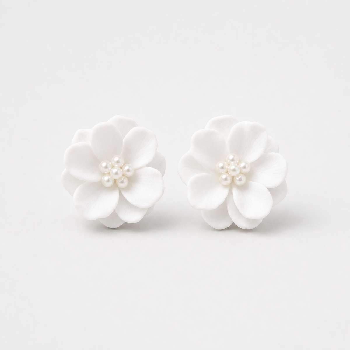 Pearl Center White Blossom Stud Earrings left and right pair on light gray background