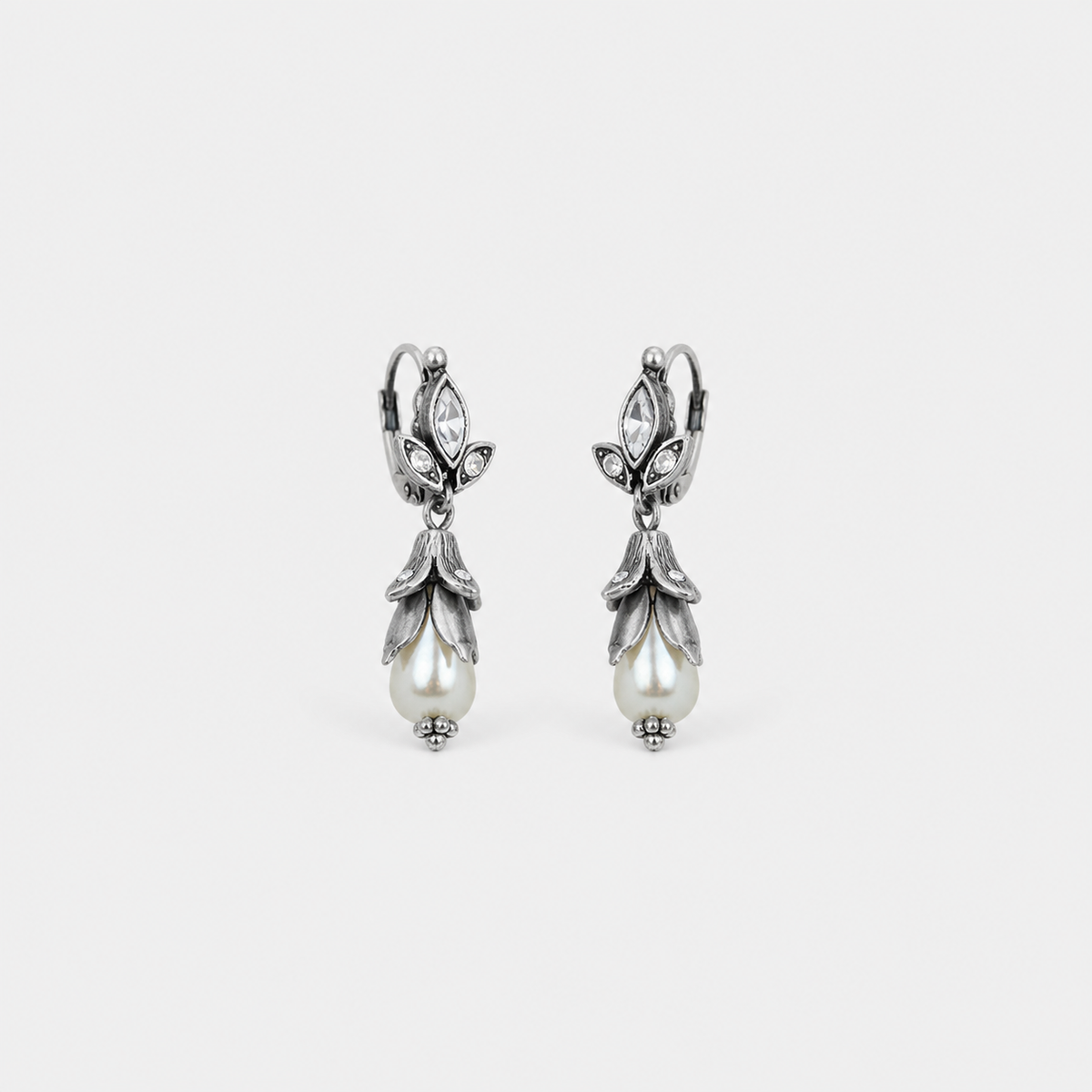 Silver Floral Lily Pearl Earrings — left and right pair on light gray background