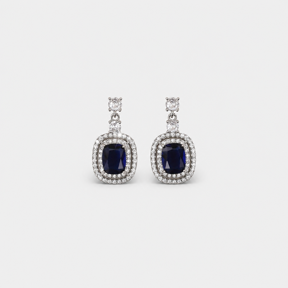Oval Sapphire Paved Zirconia Earrings — left and right pair on light gray background