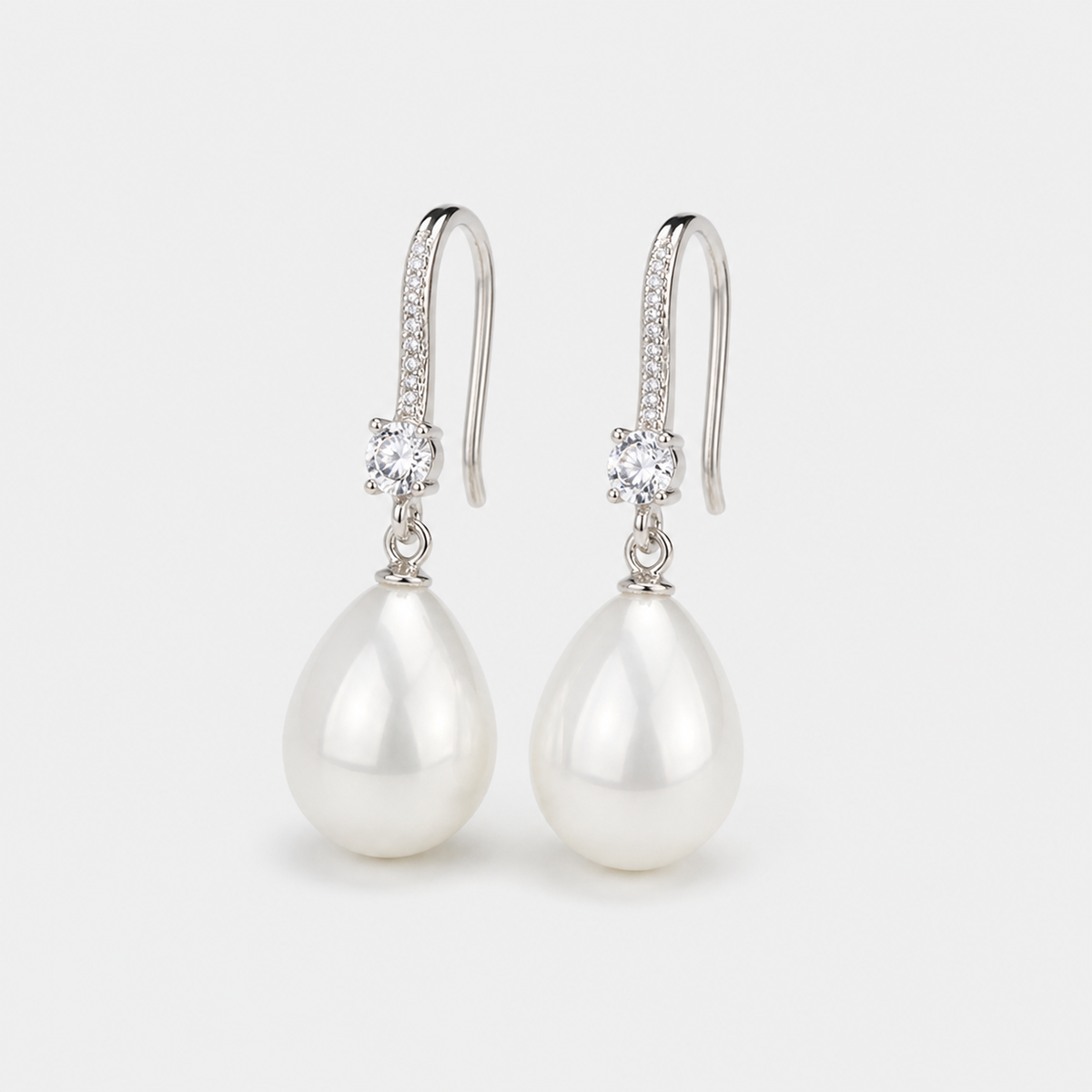 Dangling Earrings with Bright Pearls — left and right pair on light gray background