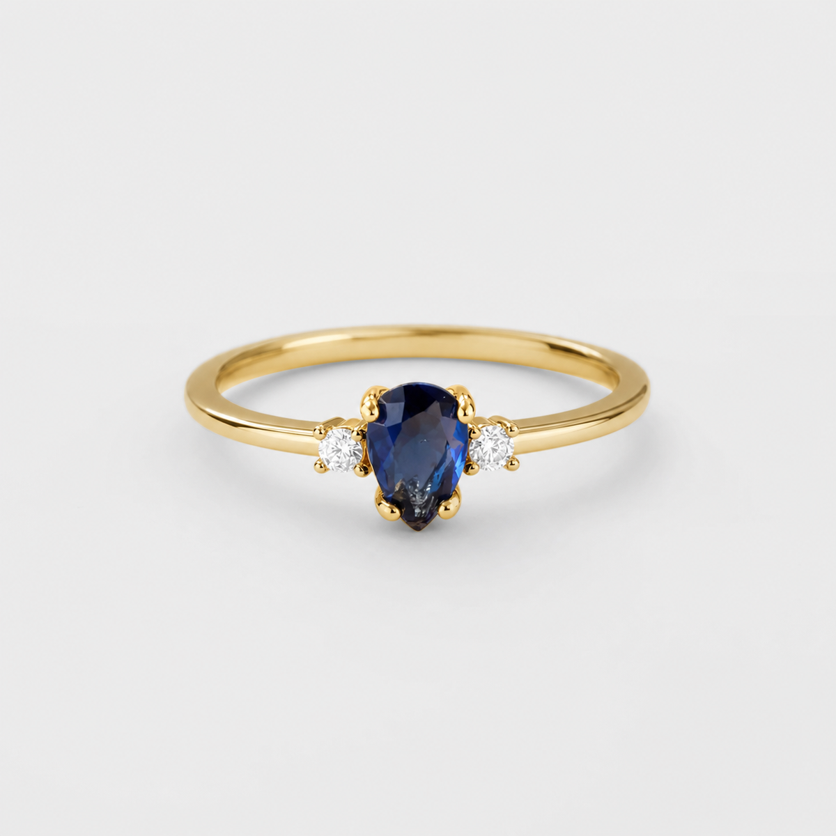 Minimalist Pear Cut Royal Sapphire Ring on light gray background
